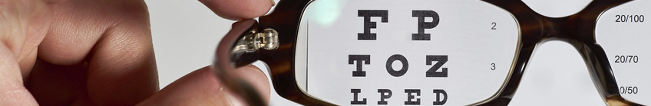 optometrist giving glasses to patient
